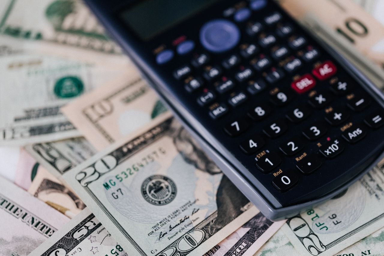 Calculator on a stack of cash, the daily record-keeping behind small business bookkeeping in Toronto