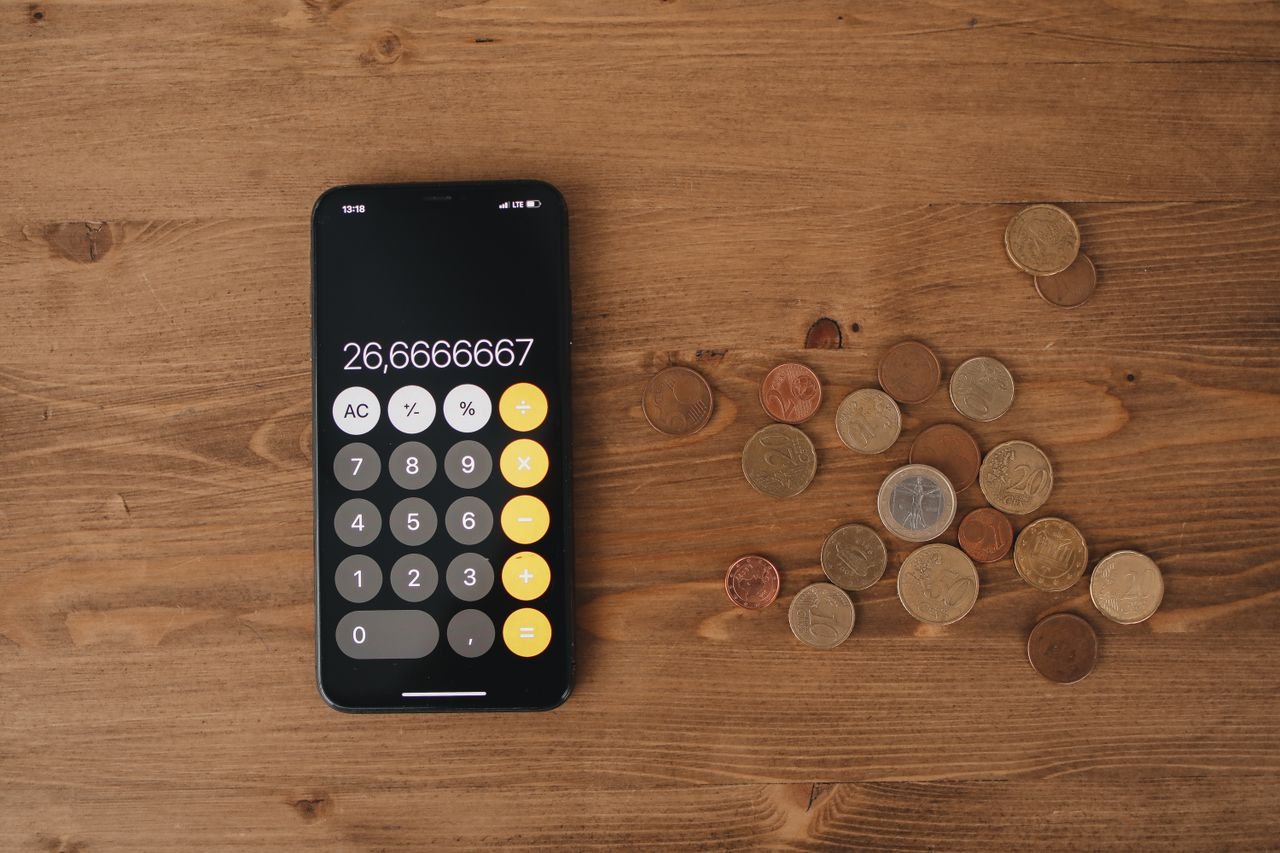 Smartphone calculator and coins for calculating payroll deductions for Ontario employers