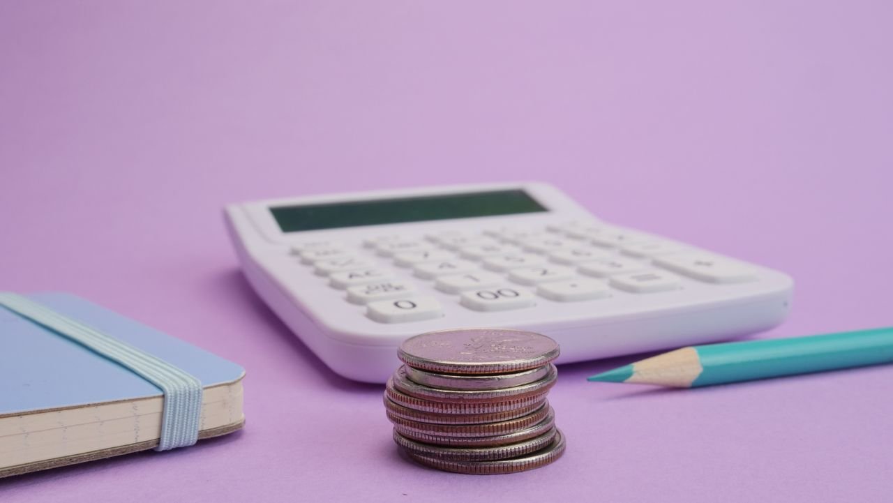 Calculator and coins used to compare salary versus dividends for an Ontario business owner
