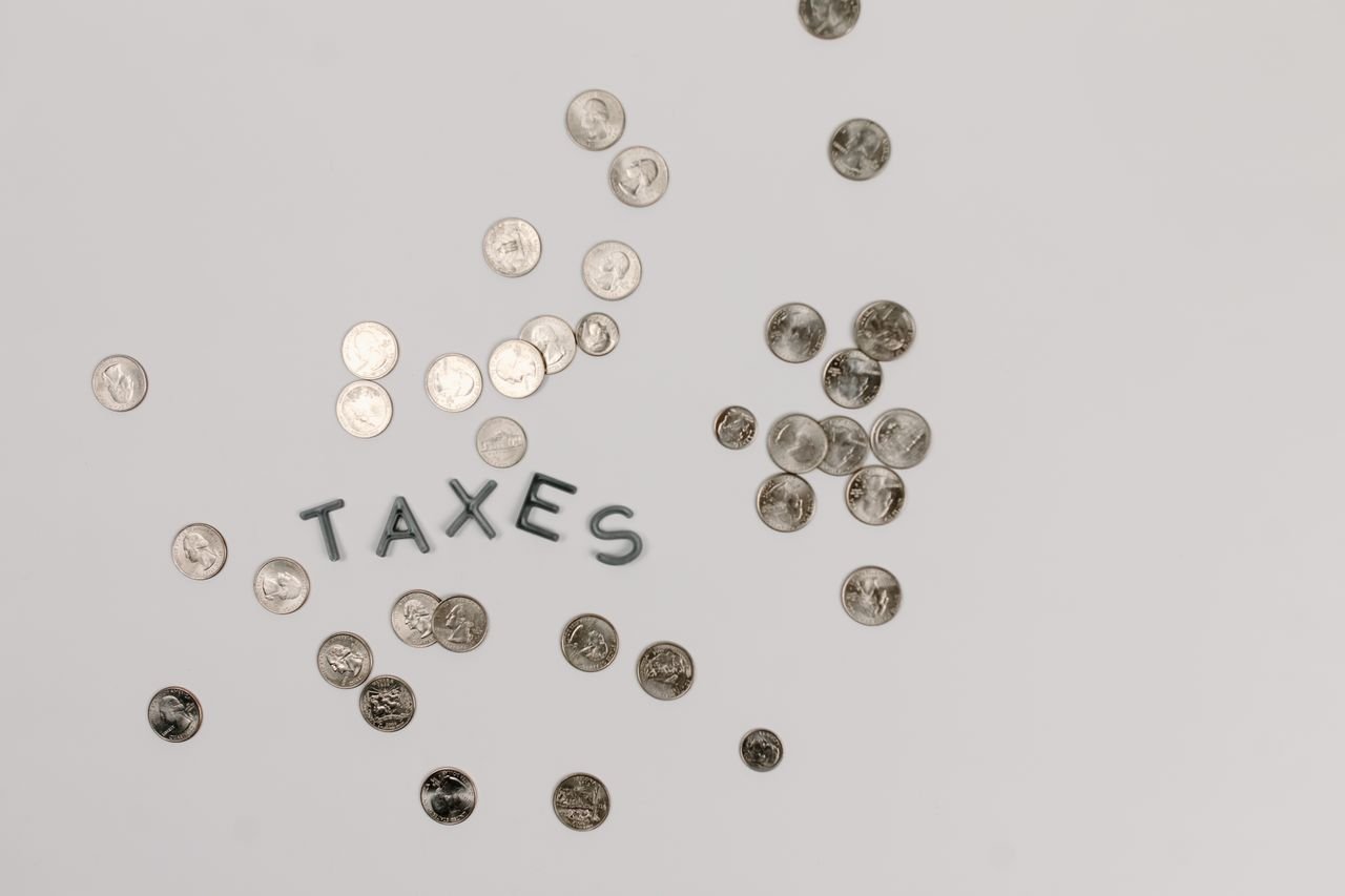 Coins forming the word taxes, a reminder of the tax on selling a business in Canada