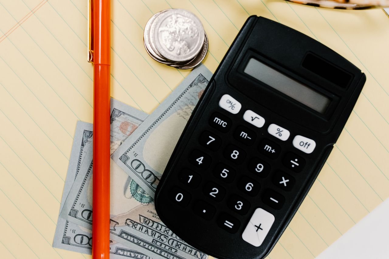 Calculator, pen and cash on a notepad for working out personal tax deductions and credits in Ontario